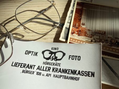 Brille und alte Fotos des ISE Optik Geschäftes.